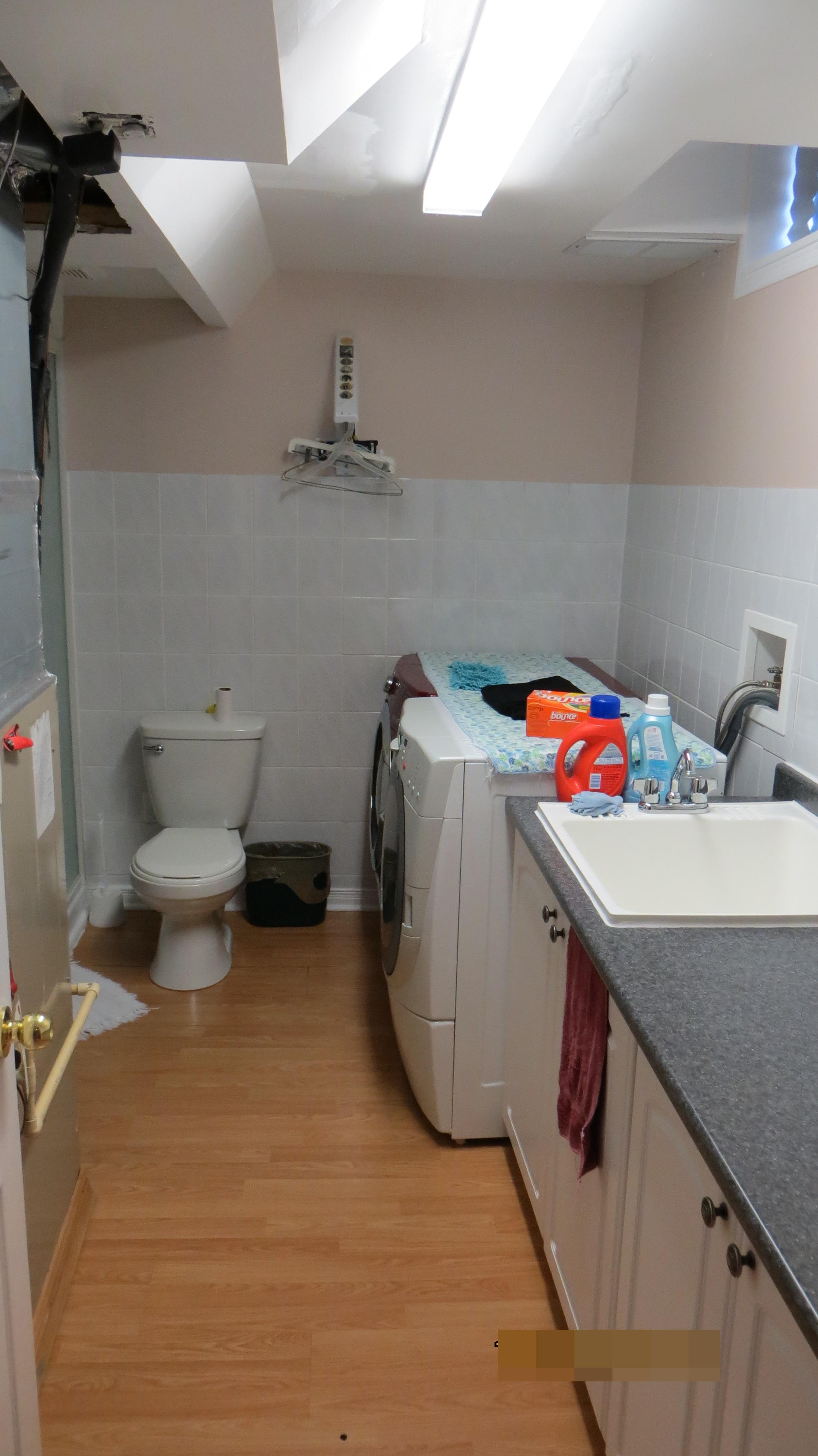 Toilet and laundry over laminate flooring